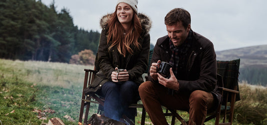 Couple sitting outside wearing Barbour Jackets and Outdoor Clothing