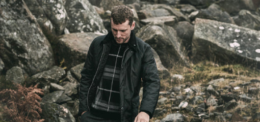 Man Trekking in Mountain Range Wearing Barbour Wax Jacket