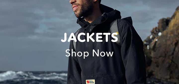 Man in a Fjallraven jacket by the sea with text overlay "JACKETS Shop Now